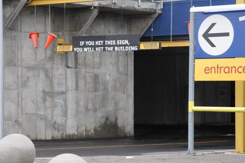 Schild an einer Durchfahrt: If you hit this sign, you will hit the building